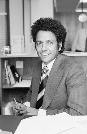 John Moriarty at his desk with books in the background.